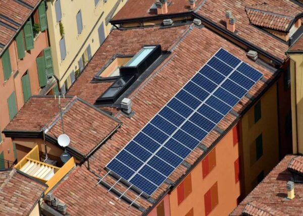 nell'immagine si vedono centri storici di una città visto dall'alto con i tetti con i pannelli fotovoltaici